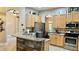 Open kitchen features stainless steel appliances, wood cabinets, and a breakfast bar counter at 1138 Lumsden Trace Cir, Valrico, FL 33594