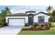 Inviting single-story home with a stone-accented facade, two-car garage, and beautifully landscaped front yard at 11332 Curio Dr, Brooksville, FL 34613