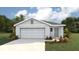 Charming single-story home featuring a two-car garage, manicured lawn, and complementary landscaping at 11771 Memorial Dr, Brooksville, FL 34613