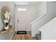 Inviting entryway with light wood flooring, modern light fixtures, and a view of the staircase leading to the upper level at 11777 Memorial Dr, Brooksville, FL 34613