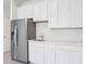 Kitchen featuring stainless steel fridge, white cabinets and quartz countertops at 11296 Curio Dr, Brooksville, FL 34613