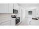 Modern kitchen with white cabinets, stainless steel appliances, and quartz countertops at 11296 Curio Dr, Brooksville, FL 34613