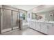 Modern bathroom featuring a glass-enclosed shower, a soaking tub, and double vanity sinks at 11352 Curio Dr, Brooksville, FL 34613