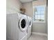 Well-lit laundry room with new washer and dryer, and practical shelving for storage at 11352 Curio Dr, Brooksville, FL 34613