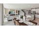 Open-concept living space with a wall-mounted TV, modern decor, and a view into the kitchen and staircase at 11352 Curio Dr, Brooksville, FL 34613