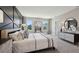 Stylish main bedroom with a geometric accent wall, large windows, and comfortable furnishings at 11352 Curio Dr, Brooksville, FL 34613