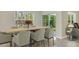 Bright dining room with a large window overlooking trees, a stylish wooden table, and comfortable seating at 11748 Memorial Dr, Brooksville, FL 34613