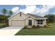 Charming single-Gathering home with a well-manicured lawn and two-car garage on a sunny day at 11748 Memorial Dr, Brooksville, FL 34613