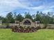 Waterford community entrance sign surrounded by lush greenery and colorful flowers at 11748 Memorial Dr, Brooksville, FL 34613