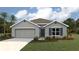 Charming one-story home with a two-car garage, gray exterior, and well-manicured lawn and mature landscaping at 11766 Memorial Dr, Brooksville, FL 34613