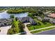Aerial view of the home with a well-manicured front yard, situated near a scenic lake and lush greenery at 305 Lake Tahoe Ct, Englewood, FL 34223