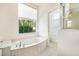 Bright bathroom featuring a luxurious tub and a separate shower, complemented by neutral tones and natural light at 305 Lake Tahoe Ct, Englewood, FL 34223