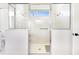 Beautiful shower room with clear glass doors, white tile and modern fixtures with a neutral color palette at 305 Lake Tahoe Ct, Englewood, FL 34223