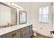 Elegant bathroom featuring double sinks, a marble countertop, and a window for natural lighting at 305 Lake Tahoe Ct, Englewood, FL 34223