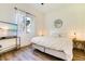 Inviting bedroom with light wood floors, a comfortable bed and soft natural light from the sheer curtains at 305 Lake Tahoe Ct, Englewood, FL 34223