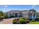 Charming single-story home featuring manicured landscaping, a gray roof, and a brick driveway with a two-car garage at 305 Lake Tahoe Ct, Englewood, FL 34223