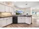 Modern kitchen featuring black countertops, backsplash, and stainless steel dishwasher at 305 Lake Tahoe Ct, Englewood, FL 34223