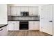 Well-lit kitchen with white cabinets, stainless steel appliances, and wood flooring at 305 Lake Tahoe Ct, Englewood, FL 34223