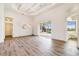 Bright living room with wood floors, tray ceilings, and large sliding doors with a pool view at 305 Lake Tahoe Ct, Englewood, FL 34223