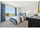 This bedroom has a large window with blue drapes, blue accents, and views of the surrounding neighborhood at 6260 Sardinia Ave, Spring Hill, FL 34608