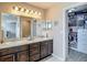 Well-lit bathroom with a double sink vanity, a large mirror, and an organized walk-in closet at 6812 Gideon Cir, Zephyrhills, FL 33541