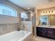 Relaxing bathroom with a large tub, glass-enclosed shower, and a stylish vanity with countertop at 6812 Gideon Cir, Zephyrhills, FL 33541