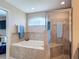 Bright bathroom featuring a soaking tub, tiled shower, and natural light from a window at 6812 Gideon Cir, Zephyrhills, FL 33541