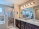 Spacious bathroom featuring double sinks, granite counters, and large framed mirror at 6812 Gideon Cir, Zephyrhills, FL 33541
