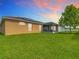 Back exterior of a single-Gathering home featuring a screened-in patio and solar panels at 6812 Gideon Cir, Zephyrhills, FL 33541
