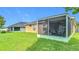 Back exterior of the house showing the lawn, screened-in patios and solar panels at 6812 Gideon Cir, Zephyrhills, FL 33541