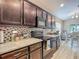 Well-lit kitchen with wood cabinets, backsplash, modern appliances, and sleek countertops at 6812 Gideon Cir, Zephyrhills, FL 33541