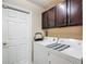 Laundry room featuring a washer and dryer set, dark upper cabinets and a nearby doorway at 6812 Gideon Cir, Zephyrhills, FL 33541