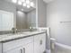 Dual sink vanity with granite countertops and ample lighting in a neutral color palette at 3018 Oceanside St, North Port, FL 34286