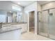 Modern bathroom with double vanity, granite counters, and glass shower with tiled walls at 3018 Oceanside St, North Port, FL 34286