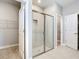 Bright bathroom featuring glass enclosed shower, tiled walls and adjacent walk in closet at 3018 Oceanside St, North Port, FL 34286