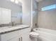 Modern bathroom features a granite-topped vanity, shower-tub combo with tiled surround, and neutral color palette at 3018 Oceanside St, North Port, FL 34286