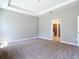 Spacious bedroom featuring plush carpet, tray ceiling and ensuite bathroom access at 3018 Oceanside St, North Port, FL 34286