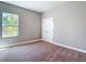 Sunlit carpeted bedroom with closet and large windows overlooking the yard at 3018 Oceanside St, North Port, FL 34286