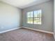 Cozy bedroom with carpet flooring and a large window providing natural light and neighborhood views at 3018 Oceanside St, North Port, FL 34286