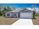 Inviting single-story home with a fresh driveway, landscaping, and attached garage at 3018 Oceanside St, North Port, FL 34286