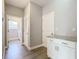 Hallway with wood flooring, cabinet with granite countertop, and access to the laundry room at 3018 Oceanside St, North Port, FL 34286