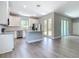 Open kitchen with stainless appliances, island, white cabinets, and wood-look floors at 3018 Oceanside St, North Port, FL 34286