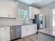 Well-lit kitchen features stainless steel appliances, white cabinets, and subway tile backsplash at 3018 Oceanside St, North Port, FL 34286