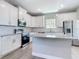 Modern kitchen boasts white cabinets, granite counters, stainless steel appliances, and an island at 3018 Oceanside St, North Port, FL 34286