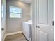 Bright laundry area with modern washer and dryer, a window, and convenient access to the house at 3018 Oceanside St, North Port, FL 34286