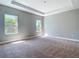 Spacious bedroom with plush carpeting, tray ceiling, and abundant natural light at 3018 Oceanside St, North Port, FL 34286