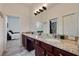 Bathroom vanity featuring cherry-wood cabinets and a granite countertop with double sinks at 205 Bengal Cir, Oldsmar, FL 34677