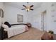 Bedroom with neutral carpet, ceiling fan, and twin bed with door to the ensuite at 205 Bengal Cir, Oldsmar, FL 34677