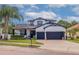 Charming two-story home featuring a two-car garage, manicured lawn, and beautiful landscaping at 205 Bengal Cir, Oldsmar, FL 34677
