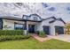 Beautiful front view of a two-story home with lush landscaping, a brick walkway, and a two-car garage at 205 Bengal Cir, Oldsmar, FL 34677